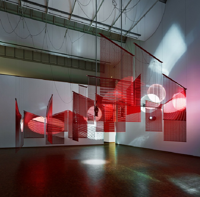 Haegue Yang, Mountains of Encounter, 2008, Aluminum venetian blinds, powder-coated aluminum hanging structure, steel wire rope, moving spotlights, floodlights, cable , Dimensions variable, Museum Ludwig, Köln, joint acquisition with the Gesellschaft für Moderne Kunst on the occasion of the 2018 Wolfgang Hahn Prize Installation view of Haegue Yang: ETA 1994–2018, Museum Ludwig, Cologne, 2018, © Haegue Yang, Photo: Museum Ludwig, Šaša Fuis, Cologne 